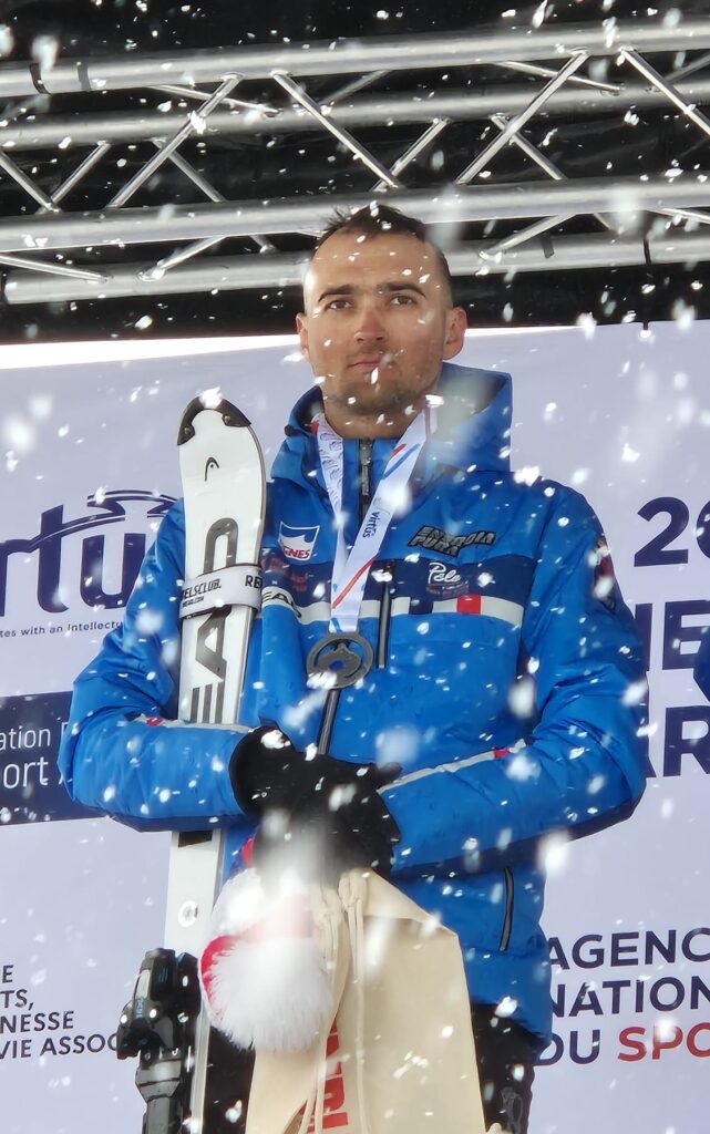 Photo de Thomas Girerd sur le podium avec une médaille autour du cou lors de Championnats du Monde Virtus de Para Ski Alpin Adapté à Tignes en 2025